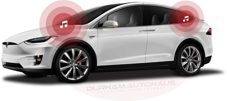 A white Tesla Model X with red-highlighted areas near the front and rear speakers, each containing a music note icon, symbolizing its premium sound system. The "Durham Autohaus" branding is subtly placed beneath the car.