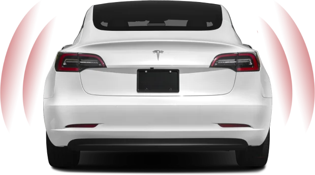 A white Tesla Model 3 viewed from the rear, displaying its sleek design and taillights. Red curved lines on either side of the car suggest the activation of parking sensors or an autonomous driving feature.